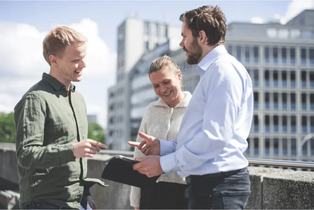 three people standing outside discussing work relaated topics